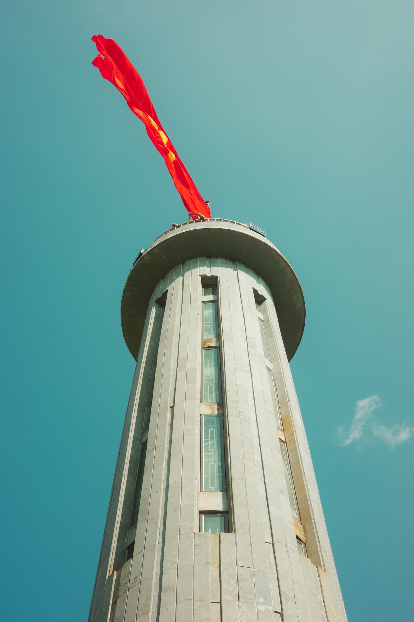 shot from below: a large tower with a Vietnam flag in the wind